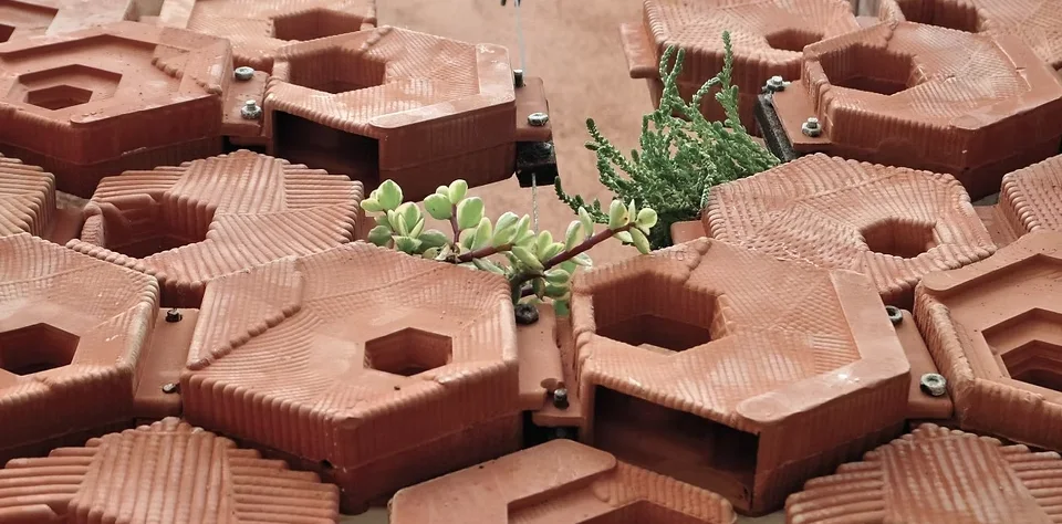 Interlocking hexagonal clay-colored modules with plants growing through them