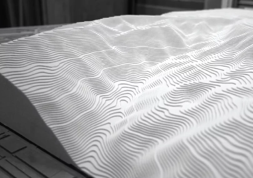 A white surface milled into a rippled topography
