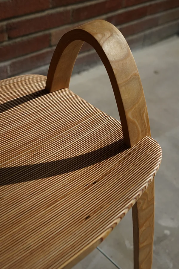 Close-up where a bow meets the seat, showing the plywood layers