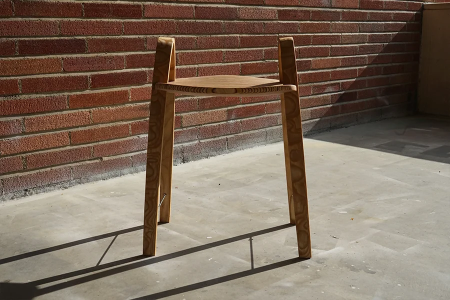 The chair from the front against a brick wall