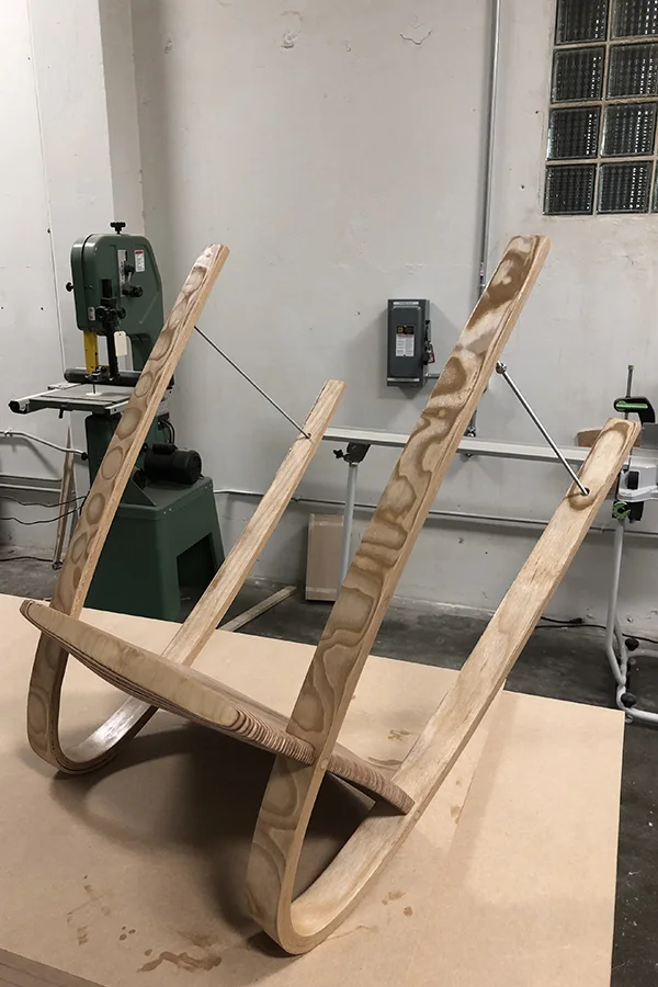 Bent plywood bows standing in a workshop, waiting for assembly