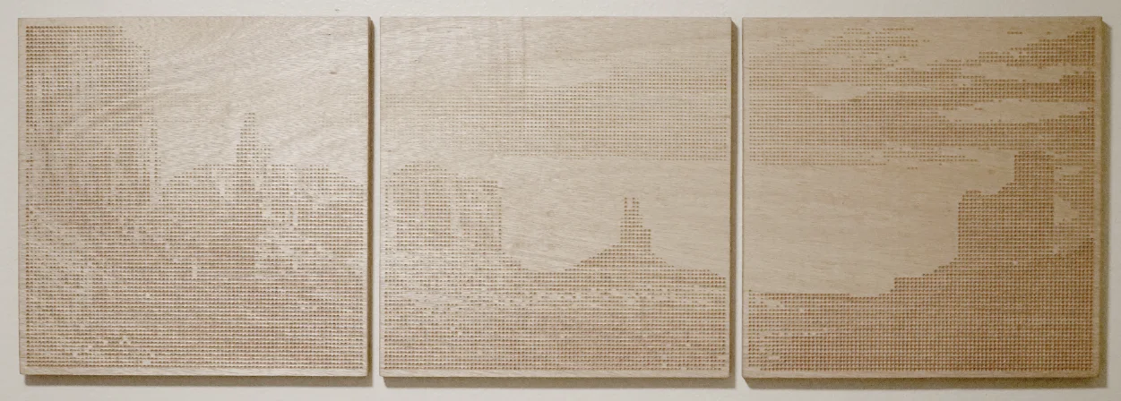 Three plywood panels side by side, a desert landscape with buttes drilled across them