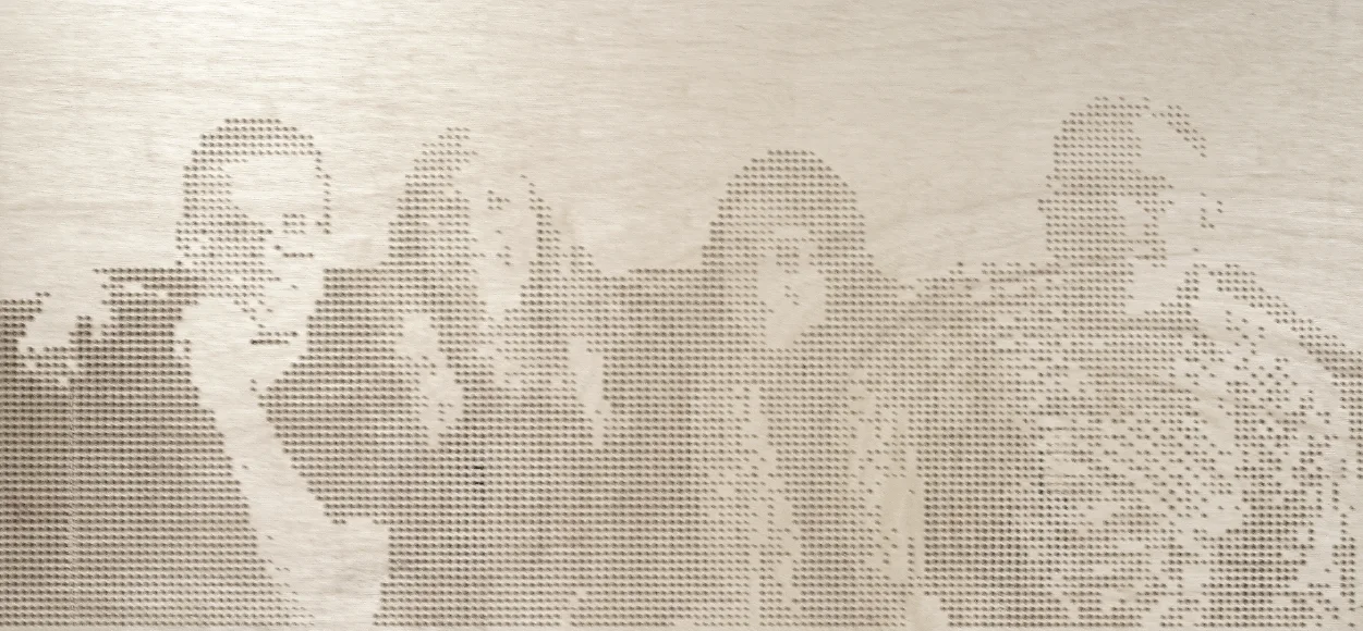 A plywood panel with a group of four people drilled into it