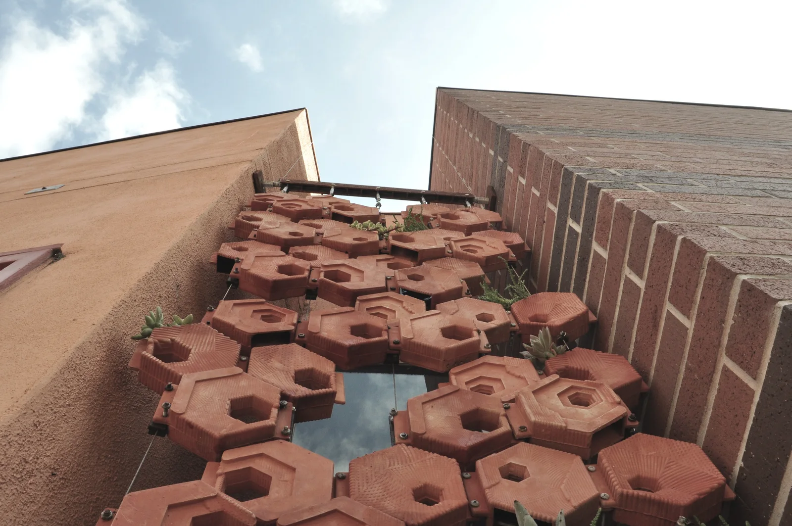 Looking up at the lattice of modules against the sky between the walls