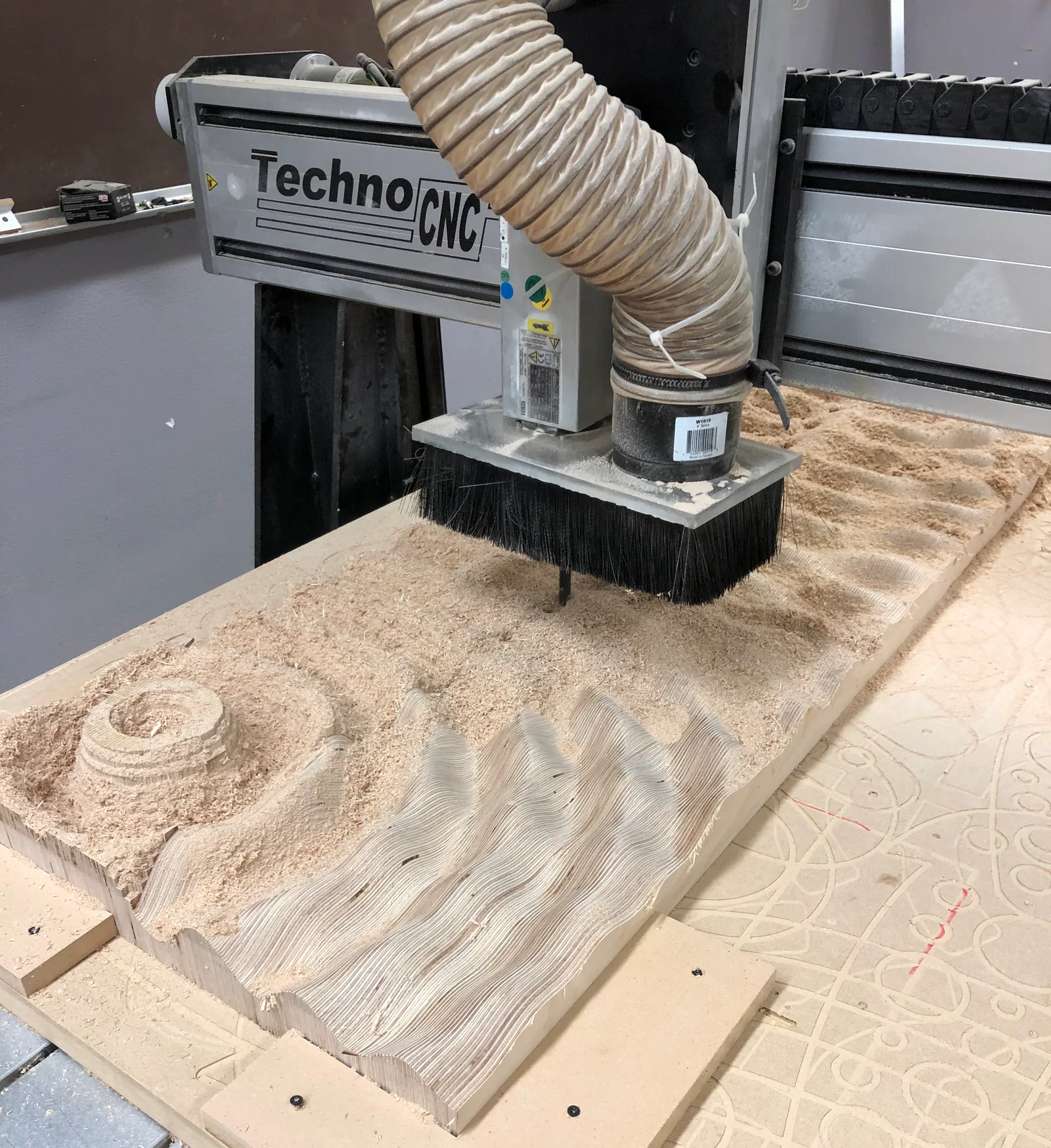 The CNC head cutting curved passes into the block